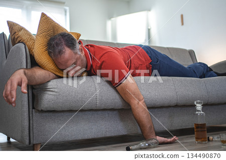 Drunk man sleeping on a sofa 134490870