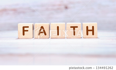 Letters spelling out the word Faith are arranged on light wooden blocks, resting upon a pale wooden surface. It conveys a message of trust and inspiration Letters spelling out the word Faith are arranged on light wooden blocks, resting upon a pale wooden surface. It conveys a message of trust and inspiration 134491262