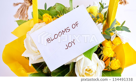 A colorful gathering of white roses and petite yellow roses are nestled in bright yellow wrapping with greenery, a delightful presentation showing Blooms of Joy A colorful gathering of white roses and petite yellow roses are nestled in bright yellow wrapping with greenery, a delightful presentation showing Blooms of Joy 134491338