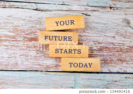 Four wood blocks are stacked on a rustic white surface with the inspiring phrase YOUR FUTURE STARTS TODAY spelled out on them. A powerful motivation statement Four wood blocks are stacked on a rustic white surface with the inspiring phrase YOUR FUTURE STARTS TODAY spelled out on them. A powerful motivation statement 134491418