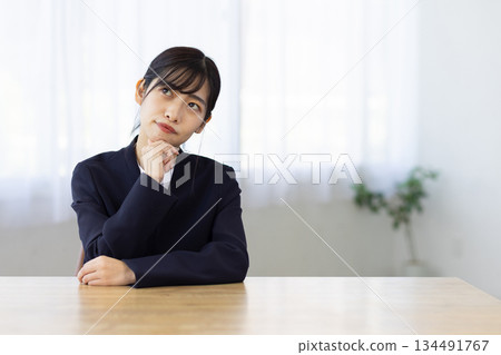 A young businesswoman thinking with her hand on her chin 134491767