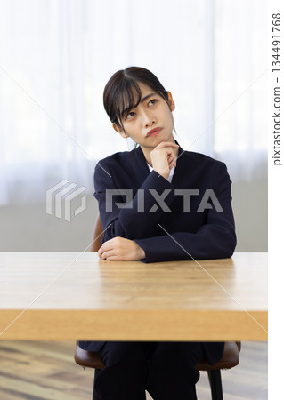 A young businesswoman thinking with her hand on her chin 134491768