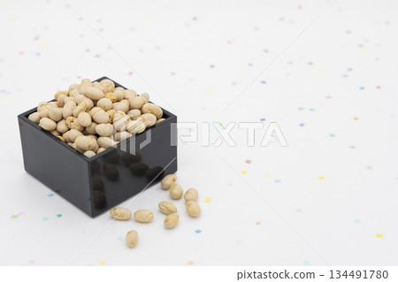 一個黑色的枡箱,盛滿烤黃豆,擺放在色彩鮮豔的日式紙背景上。這是節分的圖片素材。 一個黑色的枡箱,盛滿烤黃豆,擺放在色彩鮮豔的日式紙背景上。這是節分的圖片素材。 134491780