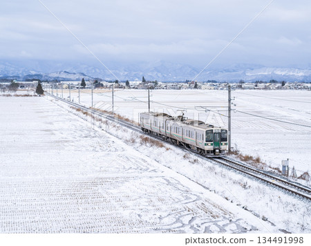 [Yamagata Line] A local train running through a winter countryside 134491998