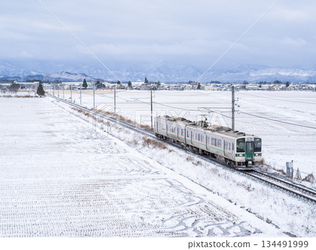 [Yamagata Line] A local train running through a winter countryside 134491999