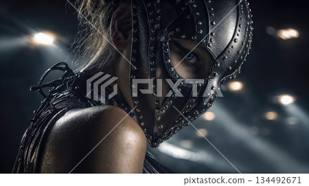 Mysterious woman in a studded dark mask gazing intensely with one eye 134492671