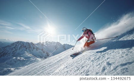 Skier carves fresh powder on a sunlit mountain slope Skier carves fresh powder on a sunlit mountain slope 134492675