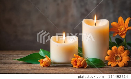 Warm candles illuminate orange flowers on rustic wood 134492814