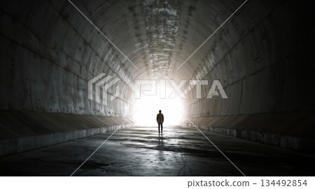 Man stands in dark tunnel, moving towards the bright exit Man stands in dark tunnel, moving towards the bright exit 134492854
