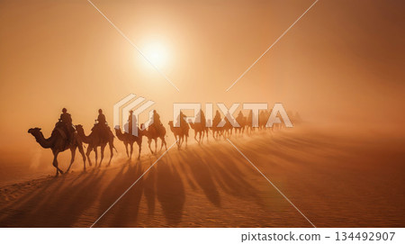 Camel caravan journeying through desert at sunset 134492907