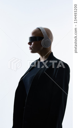 Young woman with shaved head wearing futuristic visor and headphones in profile Young woman with shaved head wearing futuristic visor and headphones in profile 134493200