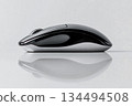 Wireless computer mouse on reflective desk surface 134494508