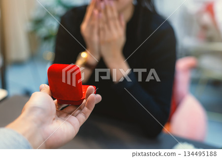 First person view of man proposing with red ring box First person view of man proposing with red ring box 134495188