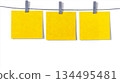 Three Bright Yellow Sticky Notes Hanging on Clothesline with Clips for Reminder, Planning, and Organization Concepts 134495481