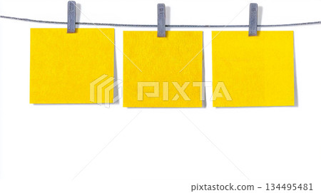 Three Bright Yellow Sticky Notes Hanging on Clothesline with Clips for Reminder, Planning, and Organization Concepts 134495481