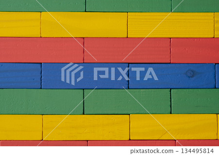 Close-up of a wall made from brightly colored wooden toy blocks arranged in a neat geometric pattern and texture, suitable for a background Close-up of a wall made from brightly colored wooden toy blocks arranged in a neat geometric pattern and texture, suitable for a background 134495814