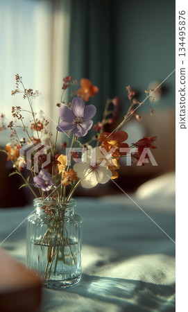 Sunlit Wildflower Arrangement In Mason Jar, Delicate Petals Illuminated By Sunlight On Soft Bedding Sunlit Wildflower Arrangement In Mason Jar, Delicate Petals Illuminated By Sunlight On Soft Bedding 134495876