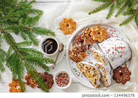 Traditional German Christmas Stollen with marzipan and cookies on white wooden table 134496376