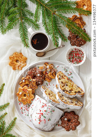 Traditional German Christmas Stollen with marzipan and cookies on white wooden table 134496377