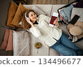 Woman listening to music packing suitcase for travel vacation 134496677