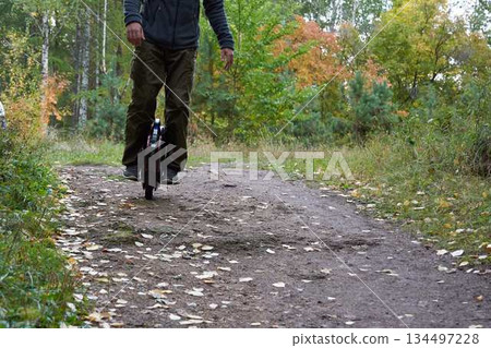 man rides down the trail on a monocycle. close up unicycle. man rides down the trail on a monocycle. close up unicycle. 134497228