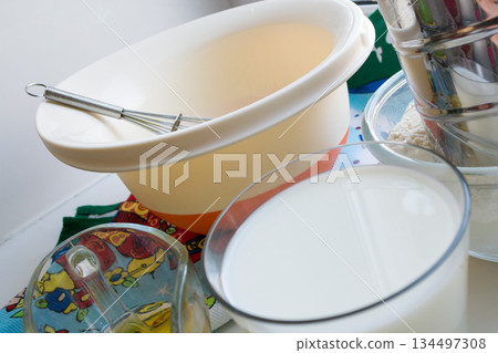 raw ingredients for pancakes are laid out on a multi-colored tablecloth and white background raw ingredients for pancakes are laid out on a multi-colored tablecloth and white background 134497308