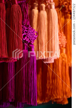 Decorative tassels with vibrant red and purple tassels and decorative knots 134497322