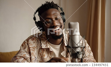African man laughing recording music or podcast African man laughing recording music or podcast 134497431