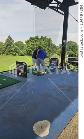 This is a man at driving range This is a man at driving range 134497884