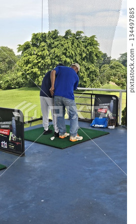 This is a man at driving range This is a man at driving range 134497885