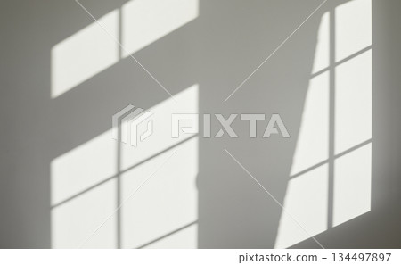 Empty grey interior wall background with light and shadows from the house windows Empty grey interior wall background with light and shadows from the house windows 134497897