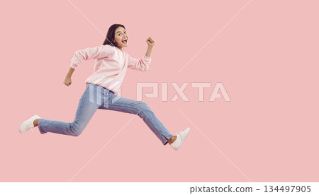 Funny energetic young woman rushes to shopping center in hurry for crazy discounts on sales. 134497905