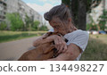 Animal theme is a lonely old woman best friend. Caucasian 90 years old senior female is happy to spend time with her pet small dachshund dog, holding her in her arms, hugging hugs and kisses outdoor 134498227
