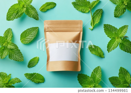 Algae snack package surrounded by fresh mint leaves on a vibrant mint backdrop 134499981