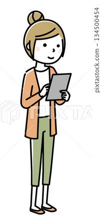 A young woman looking at a tablet A young woman looking at a tablet 134500454