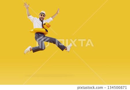 Funny cheerful businessman with inflatable swimming circle having fun on orange background. 134500871