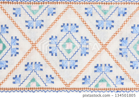Geometric ethnic embroidery pattern on white linen texture Geometric ethnic embroidery pattern on white linen texture 134501805
