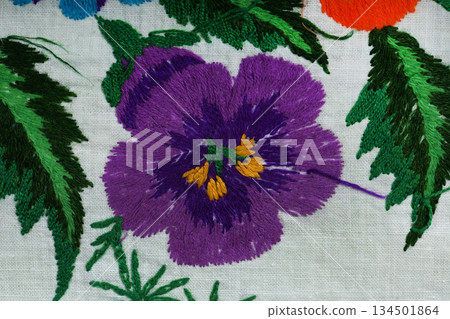 Hand embroidered purple pansy flower on white linen fabric Hand embroidered purple pansy flower on white linen fabric 134501864