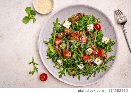 Warm beef meat salad with arugula Warm beef meat salad with arugula 134502213