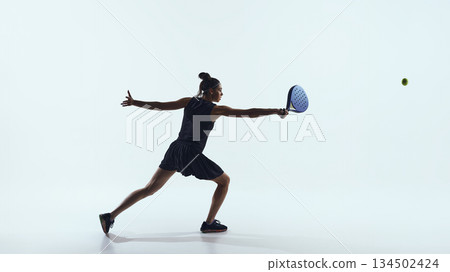 Woman extending arm to hit ball with paddle isolated on white. Woman extending arm to hit ball with paddle isolated on white. 134502424