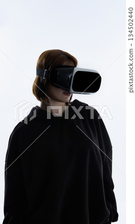 Young woman wearing virtual reality headset against white background. Young woman wearing virtual reality headset against white background. 134502440