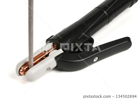 Close-up of welding electrode holder clamp gripping a rod 134502694