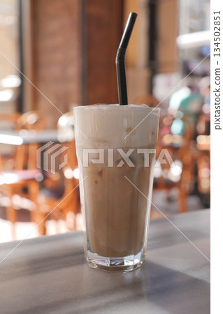 ice late served in a glass with a straw next to tables ice late served in a glass with a straw next to tables 134502851
