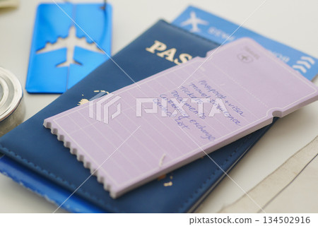Checklist for travel plans on desk with passport and tickets Checklist for travel plans on desk with passport and tickets 134502916