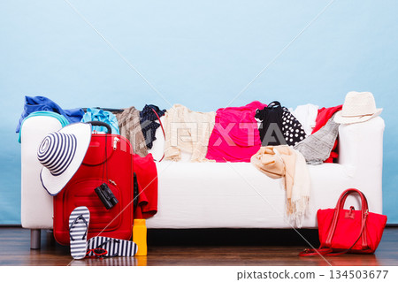 Messy colorful clothes lying on white sofa 134503677