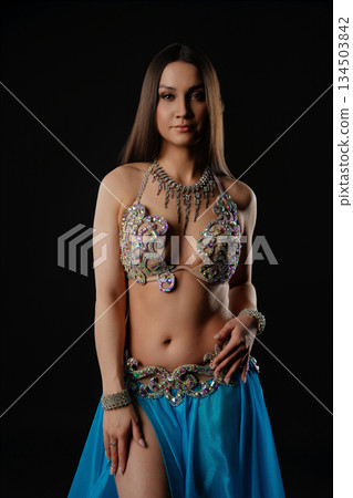 Woman performs dance with snake in dark setting during cultural event 134503842