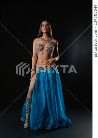 Woman dances with a snake in a dark setting at a cultural event Woman dances with a snake in a dark setting at a cultural event 134503844
