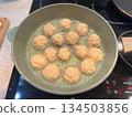 A frying pan with falafel frying in oil on a stove, ideal for Middle Eastern food blogs, vegetarian recipe tutorials, and authentic street food cooking visuals. 134503856