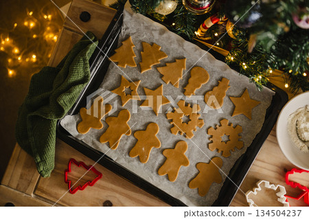 Holiday background. Uncooked raw Christmas gingerbread cookies on baking tray, lifestyle Holiday background. Uncooked raw Christmas gingerbread cookies on baking tray, lifestyle 134504237