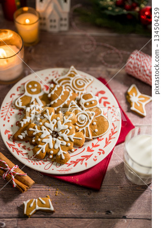Holiday background. Christmas gingerbread cookies in different shapes in a plate Holiday background. Christmas gingerbread cookies in different shapes in a plate 134504259
